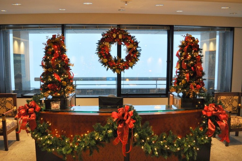 Christmas trees, wreaths and garland set up inside of an office