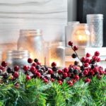 Closeup of holiday decor with evergreens, berries and candles