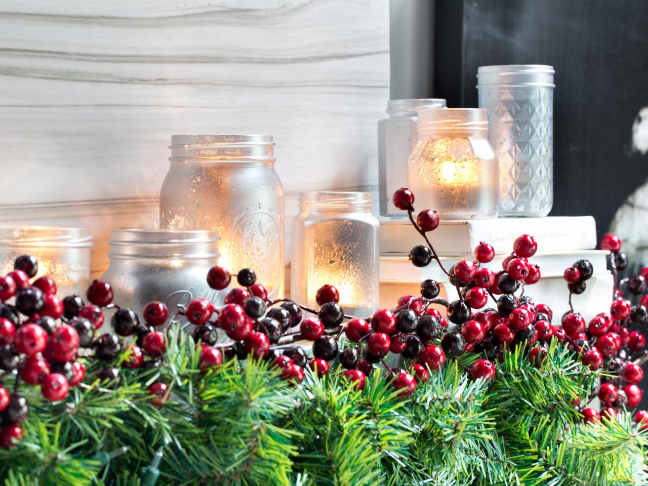 Closeup of holiday decor with evergreens, berries and candles